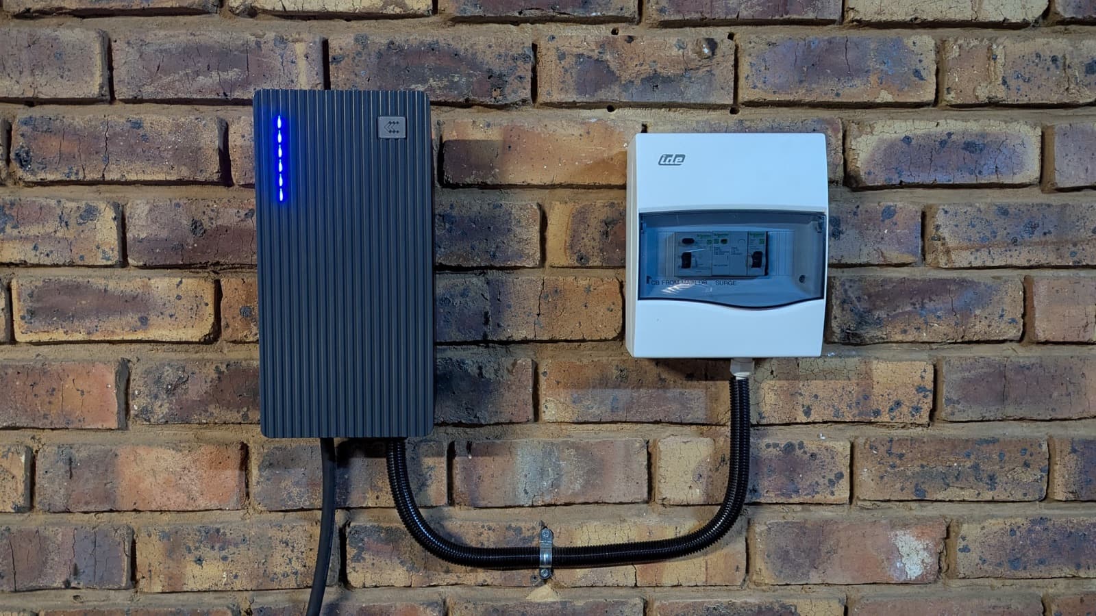 TeltoCharge unit with status LEDs next to its DB box on a brick wall